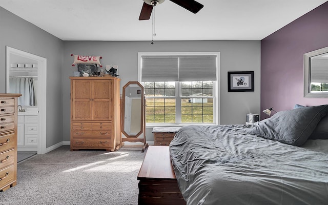 bedroom with ensuite bath, baseboards, carpet floors, and ceiling fan