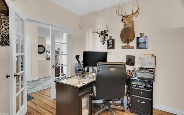 office area with french doors, light wood-style floors, and baseboards