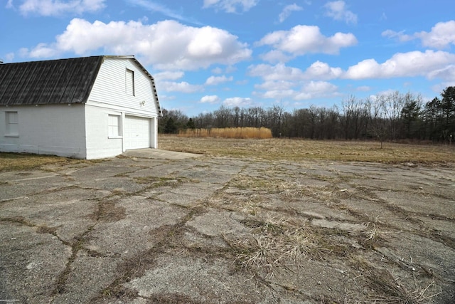 view of yard with a detached garage and an outbuilding