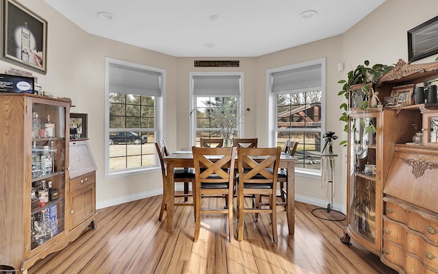 dining area with light wood-type flooring and baseboards