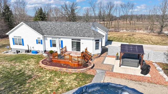 view of front of property with a shingled roof, a deck, and fence