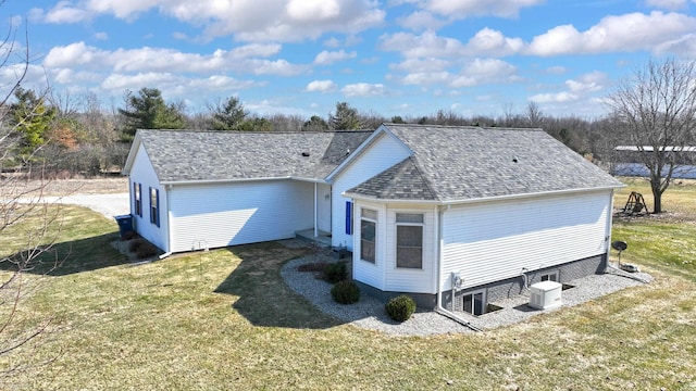 view of front facade featuring a front lawn, central air condition unit, and roof with shingles