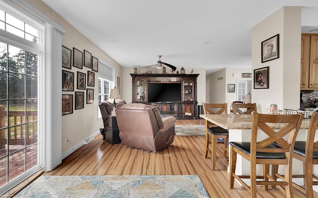 living area featuring baseboards and light wood finished floors