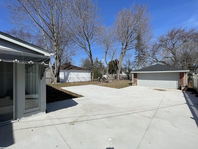 exterior space featuring a patio area, an outdoor structure, and fence