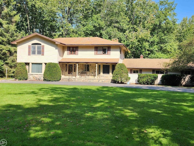 view of front of home with a front lawn, stone siding, and a chimney