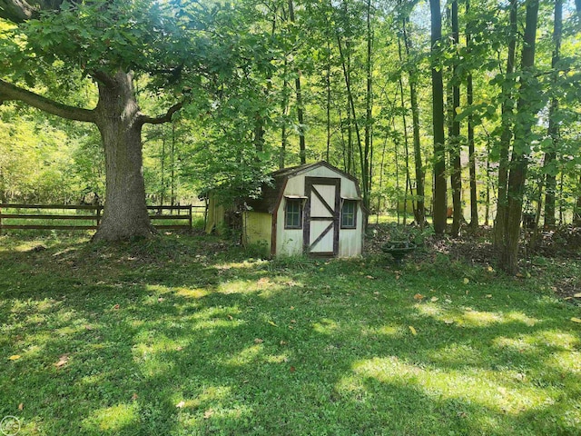 view of shed with a view of trees and fence