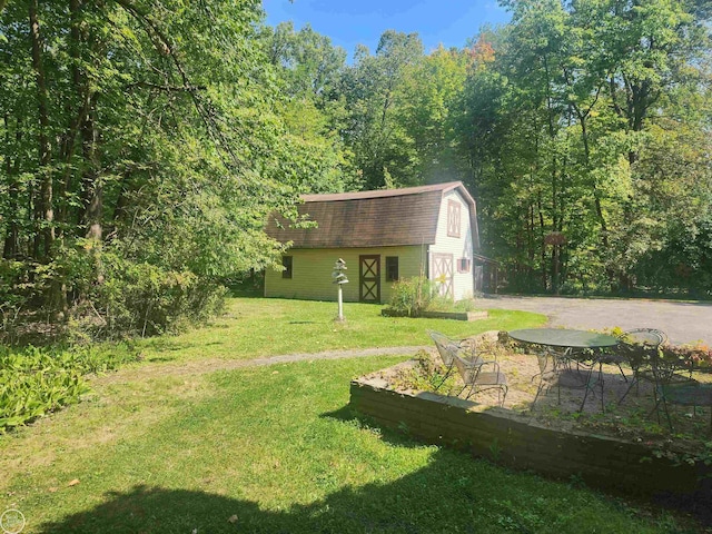 view of yard featuring an outbuilding, a barn, and driveway