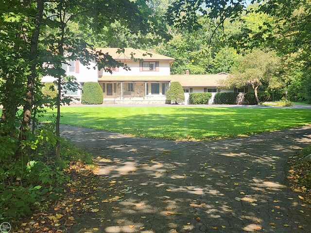 view of front facade with a chimney and a front lawn