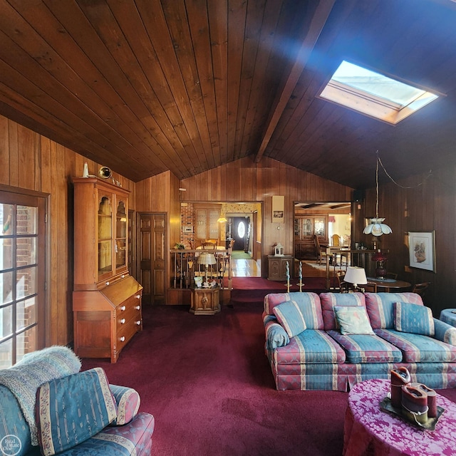 living room with vaulted ceiling with skylight, wooden walls, wooden ceiling, and carpet flooring