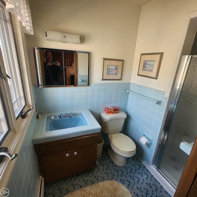 full bathroom featuring a wainscoted wall, toilet, a stall shower, tile walls, and vanity