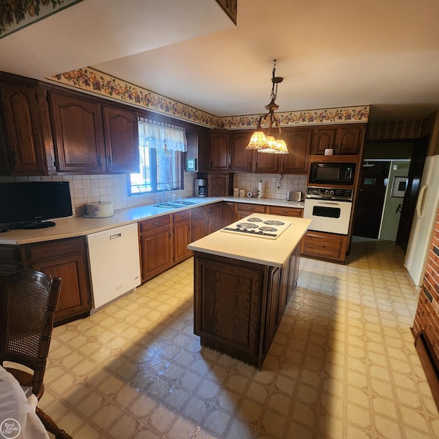 kitchen featuring white appliances, light floors, a center island, and light countertops