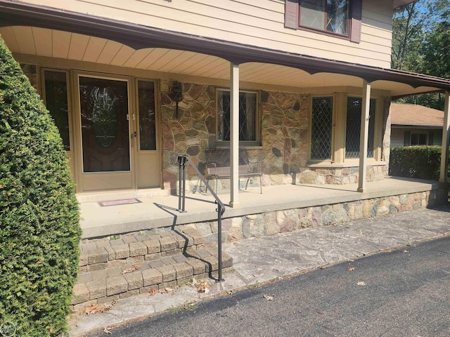 property entrance with stone siding and covered porch