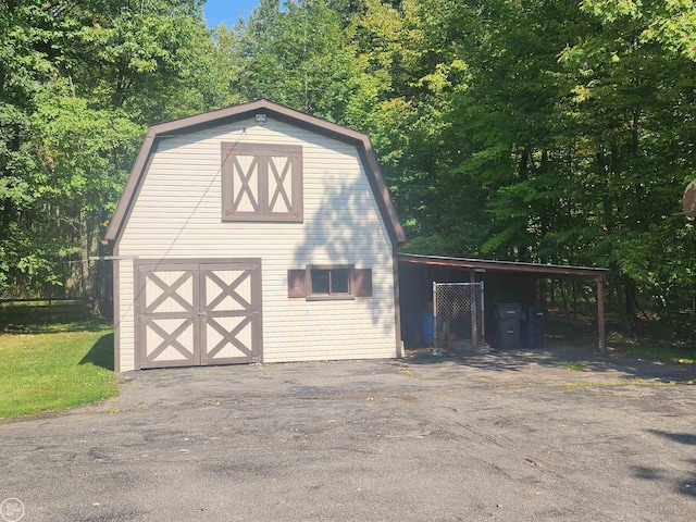 garage with aphalt driveway and a carport