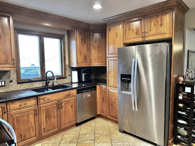 kitchen with a sink, stainless steel appliances, tasteful backsplash, and dark countertops