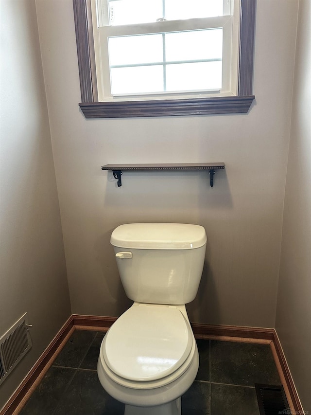 bathroom featuring tile patterned floors, visible vents, plenty of natural light, and toilet