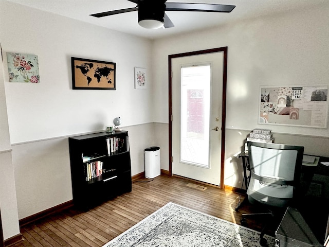 office featuring a wealth of natural light, a ceiling fan, visible vents, and wood-type flooring