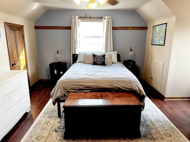 bedroom with dark wood-style flooring, baseboards, and vaulted ceiling