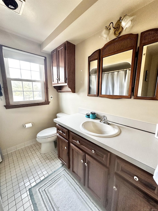 full bath featuring tile patterned floors, a shower with curtain, toilet, baseboards, and vanity