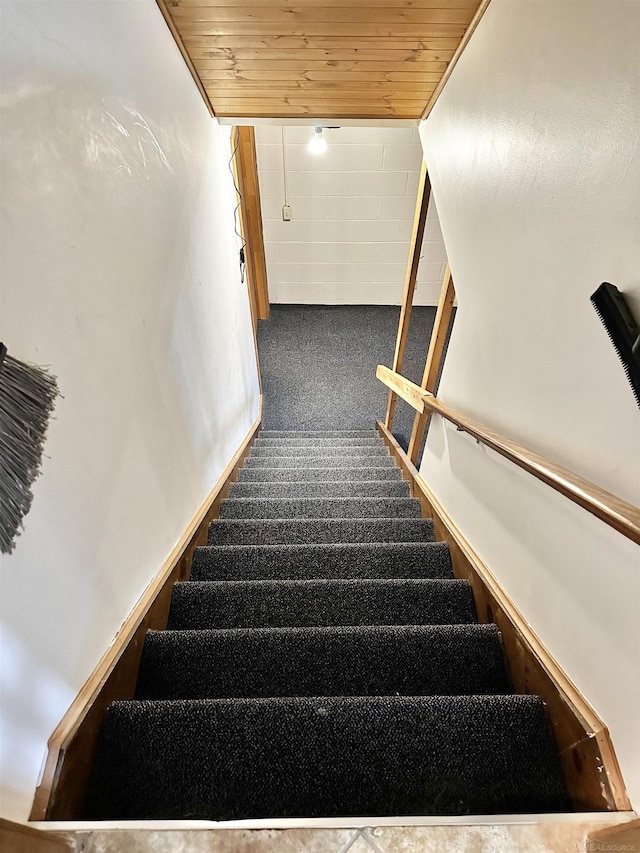 stairway featuring wood ceiling and carpet flooring