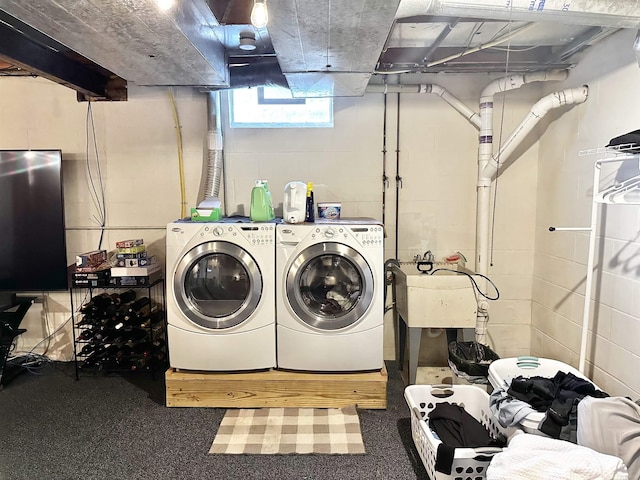 washroom with laundry area, concrete block wall, and washing machine and clothes dryer