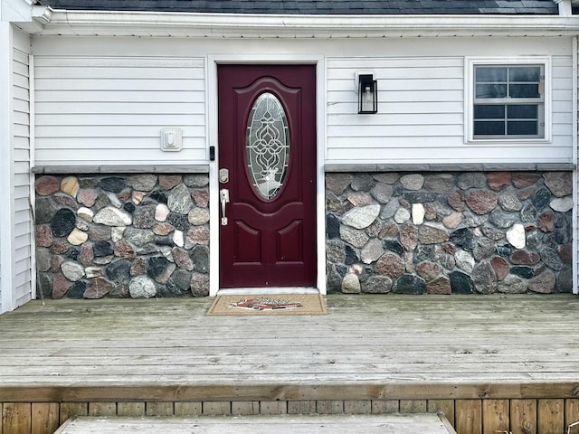 property entrance featuring a shingled roof