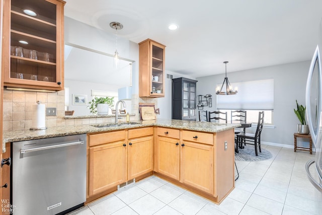 kitchen with dishwasher, light stone countertops, tasteful backsplash, and a sink