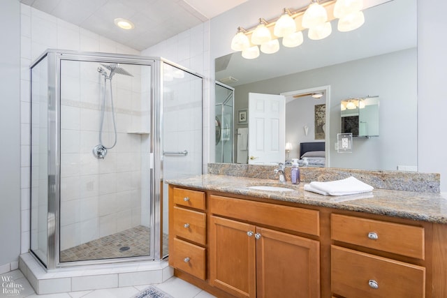 ensuite bathroom with a shower stall, vanity, vaulted ceiling, tile patterned floors, and ensuite bath