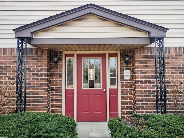 doorway to property featuring brick siding