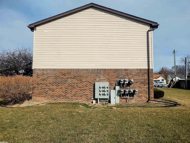 view of side of property with a yard and brick siding