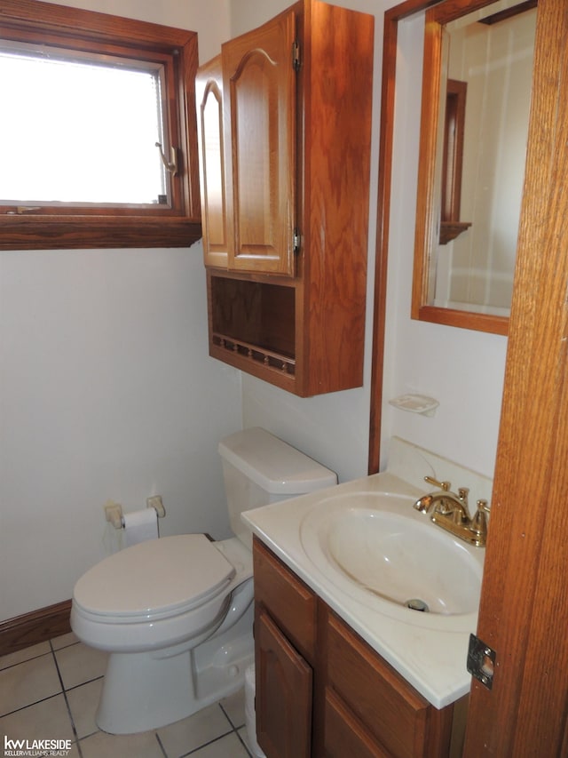 bathroom with tile patterned flooring, toilet, vanity, and baseboards