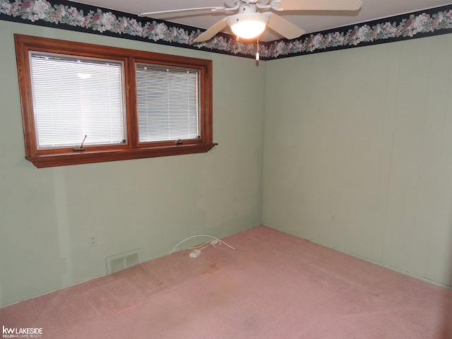 carpeted empty room with visible vents and a ceiling fan