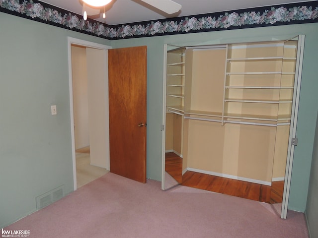 unfurnished bedroom with carpet flooring, visible vents, and ceiling fan