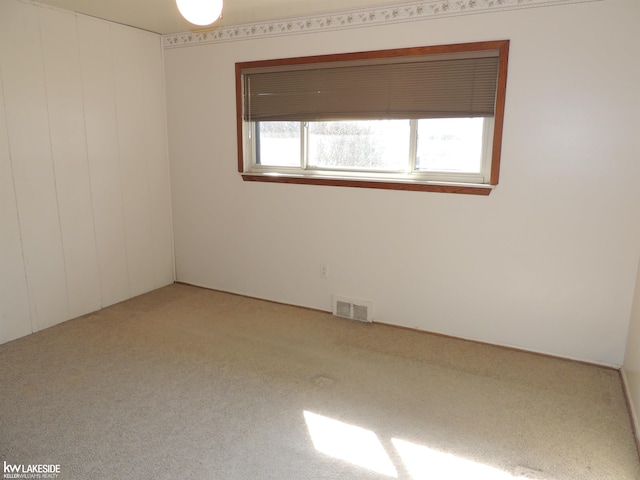 empty room featuring visible vents and light carpet