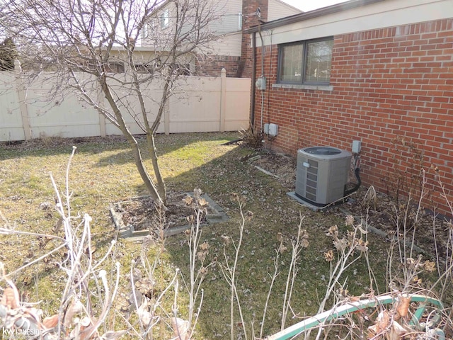 view of yard with central air condition unit and fence