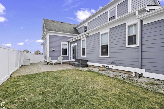 rear view of property featuring a lawn, a patio, and fence