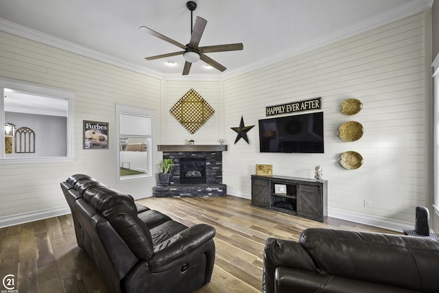 living area with a glass covered fireplace, crown molding, and hardwood / wood-style flooring