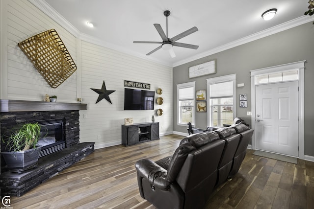 living room featuring baseboards, wood-type flooring, ornamental molding, and a fireplace