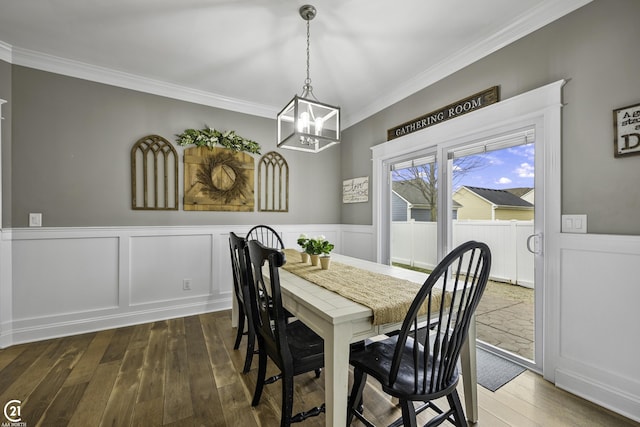 dining room featuring dark wood-style floors, a wainscoted wall, and ornamental molding