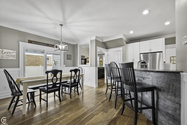 dining area with recessed lighting, a wainscoted wall, dark wood-style floors, and crown molding