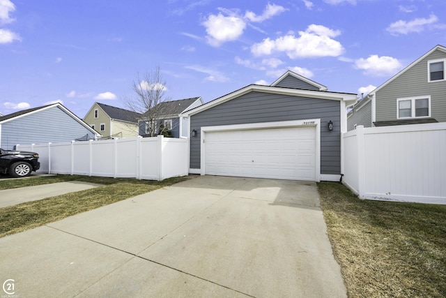 garage featuring concrete driveway and fence