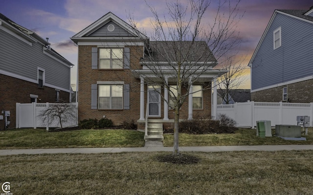 traditional-style house with brick siding and fence