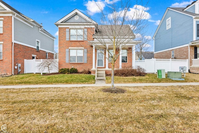 traditional-style home with a front yard, fence, and brick siding