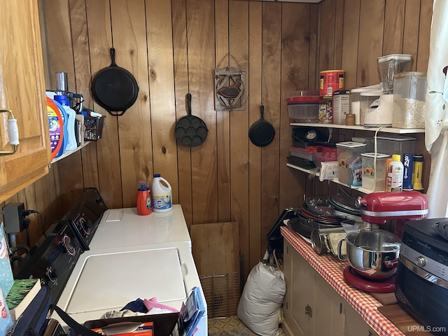 laundry room featuring washer and dryer, wood walls, and laundry area