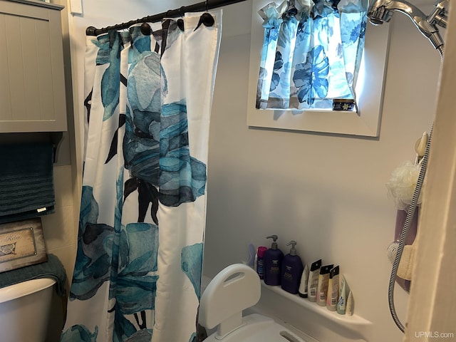 bathroom featuring toilet and a shower with shower curtain