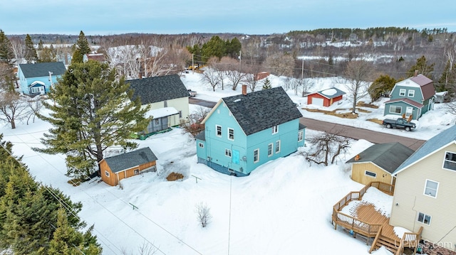 snowy aerial view with a wooded view