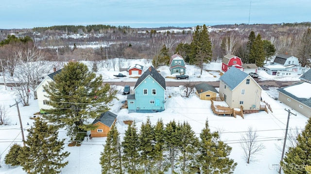 snowy aerial view featuring a residential view and a view of trees