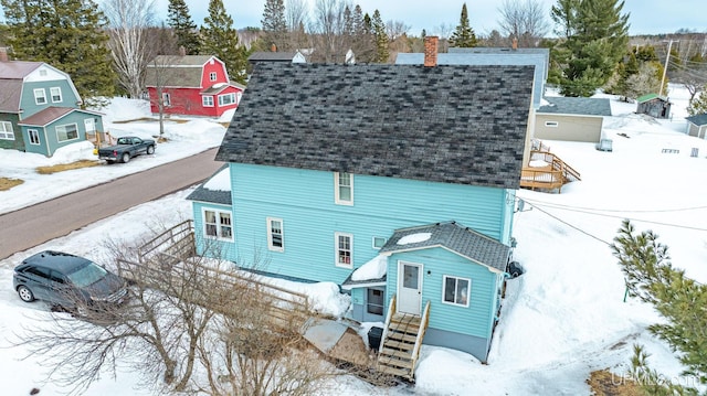 exterior space featuring a chimney and a shingled roof