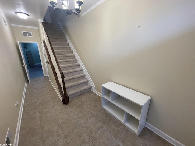 stairs featuring baseboards, visible vents, an inviting chandelier, ornamental molding, and tile patterned flooring