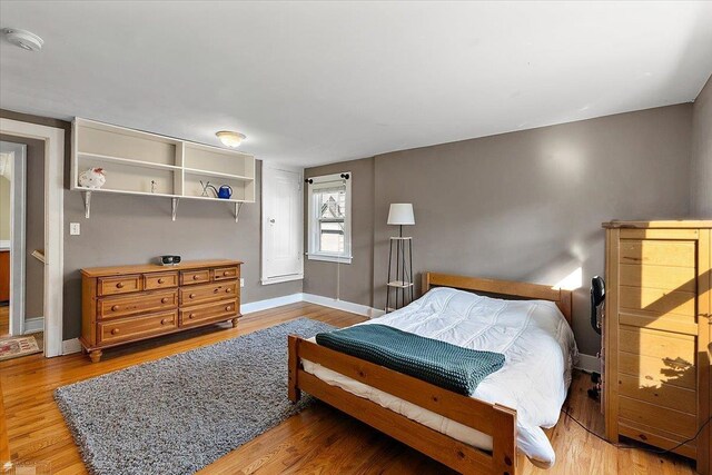 bedroom featuring baseboards and wood finished floors