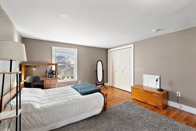 bedroom featuring a closet, baseboards, and wood finished floors